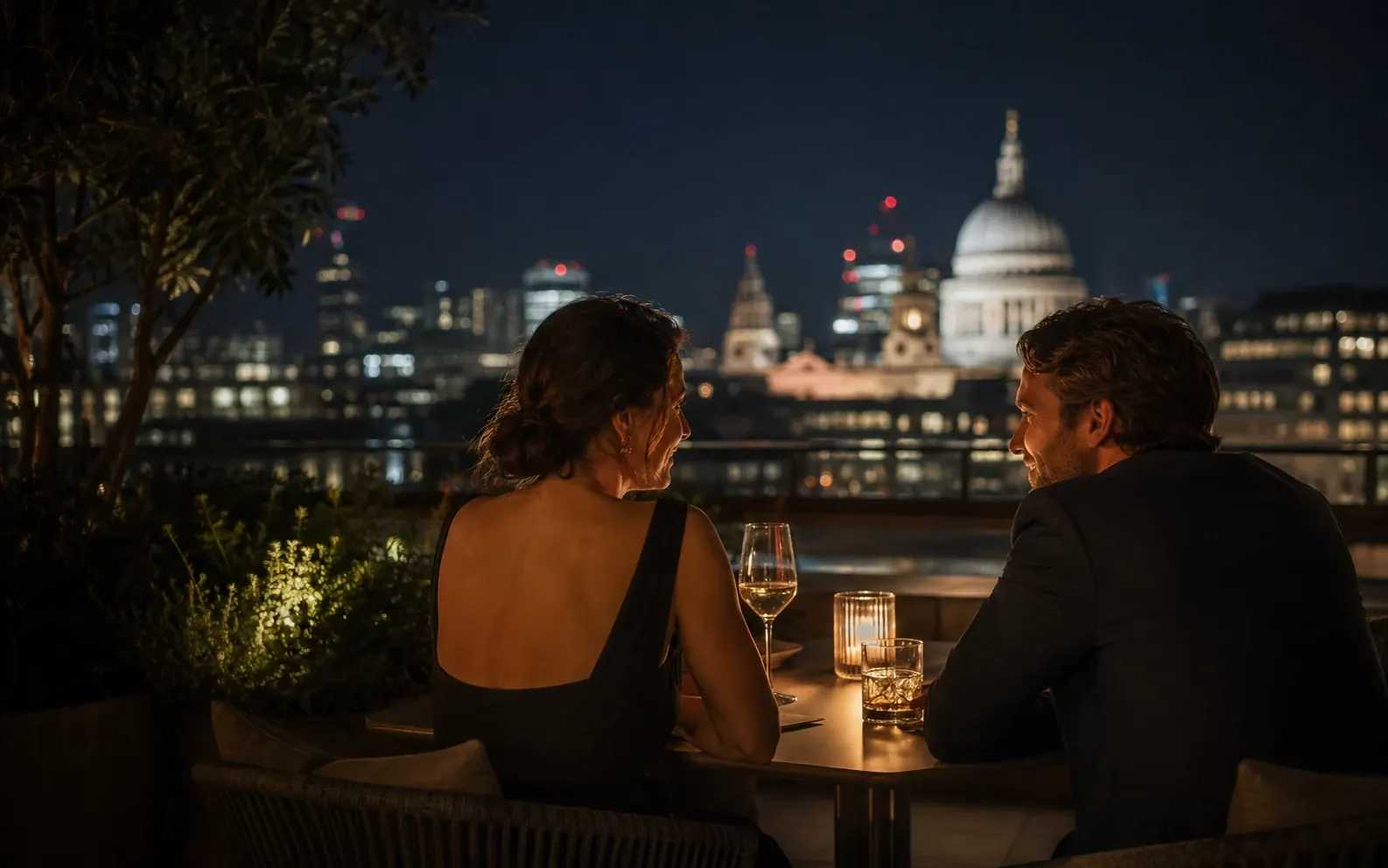 Two adults talking over drinks at a London rooftop restaurant